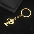 Golden letter P keychain with white rhinestones on a textured black background - Letter P Style / Gold