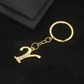 Golden alphabet Y keychain pendant with sparkling rhinestone inlay on a dark background - Letter Y Style / Gold