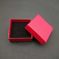 Macro detail of red faux leather jewelry box featuring textured diamond pattern - Red