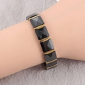 Close-up of trendy magnetic bracelet featuring black ceramic diamond facets on a wrist - Black Gold Style