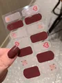 Detailaufnahme von dunkelrotbraunen Nagelstickern mit roten Herzen und Sternenmustern - Nacktes Blatt (PDD209)