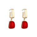 Detail view of vintage gold chain earrings with red geometric stones on white background - Red