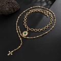 Gold-layered body chain with green stone sun pendant and cross charm on black background - Gold (06902)