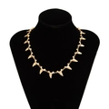 Golden shark tooth charm necklace on a black neck bust with polished metal links - Necklace / Gold
