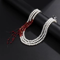 Dettaglio macro di una collana di perle a tre strati con perle marmorizzate e frange rosse - Tonalità Argento (01898)