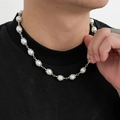 Close-up of men's pearl necklace featuring metallic petal caps and a hip-hop aesthetic - White