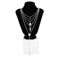 Detalle de collares plateados de varias capas con colgantes de cruz sobre busto negro - Blanco K/Plata
