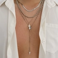 Détail de colliers superposés argentés avec pendentifs croix et chaîne serpent sur chemise - Argenté