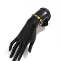 Bracciale a maglia marina dorata con gemme colorate e pavé su un modello di mano nera - Bracciale d'Oro (02993)