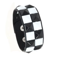 Dettaglio di bracciale punk in pelle con borchie a scacchiera e chiusura a scatto regolabile - Doppia fila