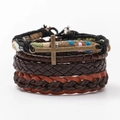 Dettaglio di un set di braccialetti in pelle punk vintage con cordini intrecciati e croce di bronzo - Marrone