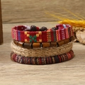 Gros plan sur un ensemble de bracelets bohèmes multicouches avec perles et fibres de jute - Style Tissé Vintage Rouge et Jaune (6)