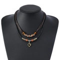 Vintage layered wooden bead necklace with bronze heart pendant on a display neck model - Hollow Heart Pendant Style