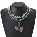 Collier papillon à trois rangs avec perles turquoise et pendentif argenté sur mannequin - Style Pendentif Papillon Ajouré