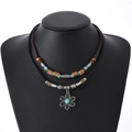 Détail d'un collier bohème avec pendentif fleur vintage et perles turquoise polies - Style Fleur à Six Pétales Fausse Turquoise