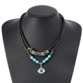 Détail d'un collier bohème double couche avec pendentif Evil Eye et perles ethniques colorées - Style Pendentif Mauvais Œil