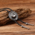 Dettaglio del bolo tie a forma di cappello cowboy con cordino in pelle intrecciata - Cappello da Cowboy Argento Antico