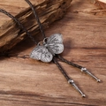 Vintage Bolo Tie mit Schmetterlingsanhänger, brauner Kordel und verzierten Metallspitzen - Kaffee Leder