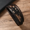 Detailed macro view of men's leather braided bracelet with black snake charm on wood - Brown