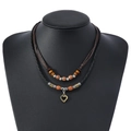 Détail d'un collier double couche vintage avec perles en bois et pendentif coeur - Style Pendentif Cœur Évidé