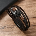 Detail van meerlagige leren armband met tijgerkopmotief en magnetische sluiting - Bruin