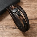Close-up of men's multilayer leather bracelet featuring a matte black skull charm detail - Leather Bracelet / Brown