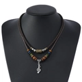 Détail d'un collier multicouche vintage avec pendentif clé de sol et perles colorées - Style Note de Musique Clé de Sol