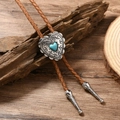 Detail of a heart-shaped blue turquoise bolo tie with silver bohemian carving and brown leather - Camel