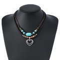 Détail d'un collier bohème à double couche avec perles turquoise et pendentif cœur - Style de Cœur Évidé Double Couche
