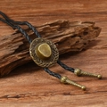 Macro view of bronze cowboy hat bolo tie pendant with braided black leather rope texture - Antique Bronze Cowboy Hat