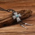 Close-up of vintage silver bolo tie with turquoise cross on a textured wooden branch - Cross Style (RH668-4)
