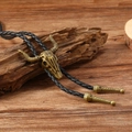 Close-up of vintage bronze bull skull bolo tie with detailed texture on wood - Antique Bronze Bull Skull