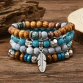Detail eines böhmischen mehrlagigen Armband-Sets mit Türkisperlen und Silberfeder-Anhänger - Naturholzperlen Federanhänger Stil (4)