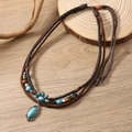 Bohemian multilayer turquoise necklace with turquoise pendants on a rustic wood background - Multicolor
