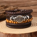 Retro punk leather bracelet with solar pattern and compass charm on wood surface - Brown