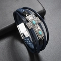 Close-up of multilayer navy leather bracelet with silver cross and turquoise inlay - Blue