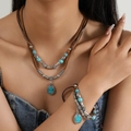 Detail of bohemian layered necklace and bracelet set with turquoise beads and silver charms - Turquoise Pendant Necklace And Bracelet Set