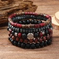 Détail d'un lot de cinq bracelets en perles avec pendentif en métal gravé d'un soleil - Ensemble de 5 pièces Flocon de Neige Rouge