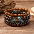 Détail de bracelets multicouches en perles de bois ethniques avec touches de turquoise - Ensemble de 5 pièces Gravier