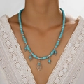 Collana bohémien con perline turchesi e pendenti a foglia d'argento indossata da modella - Ciondolo a Foglia Etnico Bohemien (RH798) / Celeste