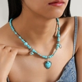 Bohemian halsketting met turquoise hartvormige hanger en zilveren kralen bij model - Hartstijl