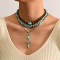 Detail van gelaagde turquoise kralenkettingen met een vintage zilveren stierenkop - 01 Koeienschedel Turkoois Halsketting Set