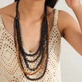 Detail einer mehrlagigen Boho-Halskette mit Holzperlen und Tigeraugen auf Modell - Schwarzes Tigerauge-Texturdesign (复古项链:款式四)