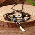 Detail of ethnic handmade beaded bracelets with wood beads and tusk pendant on wood - Bracelet 12