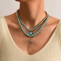 Detail van gelaagde turquoise kralenketting met hart- en strikvormige hangers - 09 Strik Hart Halsketting Set