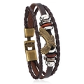 Macro view of multi-layer braided leather bracelet with eagle charm and metal beads - Brown + Bronze