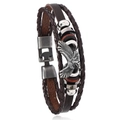 Detail of multi-layer woven leather bracelet featuring a silver eagle charm and metal clasp - Brown + Antique Silver