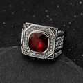 Macro detail of men's stainless steel ring with square red gemstone and pavé diamonds - Steel + Red Stone