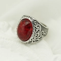 Detail of vintage silver ring featuring a large oval red gemstone and ornate engraving - Steel Band + Red Stone