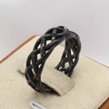 Dettaglio dell'anello a treccia in acciaio inossidabile nero con design traforato su espositore - US 7 / Nero
